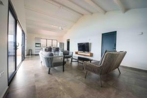 a living room with chairs and a couch and a table at Lagun Sunset Resort All Natural Clothing Optional in Lagun