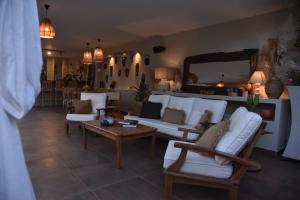 a living room with white furniture and a mirror at Soas Suites in Alacati