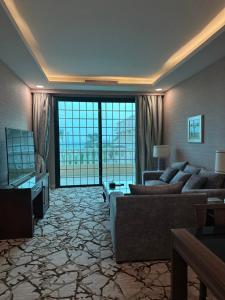 un ampio soggiorno con divano e TV di فندق حدائق فرسان الفندقية a Ḩumr