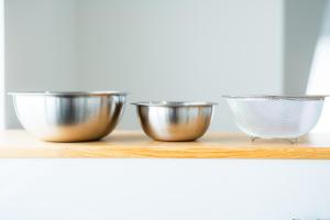 three metal bowls sitting on a wooden shelf at 貸切アパートメントSign Palace サインパレス in Kagoshima