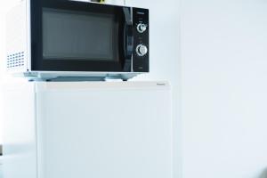 a microwave oven sitting on top of a white table at 貸切アパートメントSign Palace サインパレス in Kagoshima +22 photos