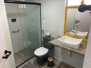 a bathroom with a shower and a toilet and a sink at Praia de Ponta Verde com lavadora, wi-fi, garagem - quarto andar in Maceió