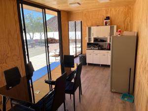 a kitchen with a refrigerator and a table and chairs at Tulahuen la cisterna in Piedra Lisa