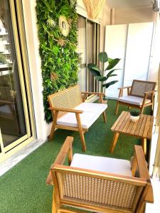 eine Terrasse mit Stühlen und einer grünen Wand in der Unterkunft New apartment at 150m from the beaches Easy check in in Juan-les-Pins
