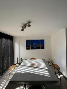 a dining room with a table and two windows at Departamento 1 dorm amoblado c/cochera in Cordoba
