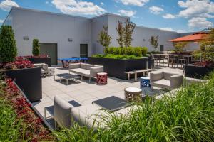 a patio with couches and tables and plants at Wonderful 2BR Condo At Crystal City With Rooftop in Arlington