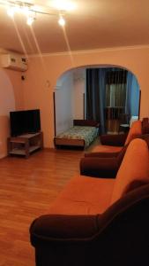 a living room with three couches and a television at Apartment on Abazgaa 53-4 in Gagra