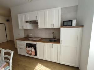 a kitchen with white cabinets and a microwave at Holiday Home Ischia in Ischia Town