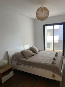 una camera da letto con un grande letto e una finestra di Duplex luxe - Résidence privée - Casablanca/Bouskoura a Bouskoura