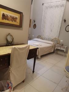 um quarto com uma cama, uma secretária e uma janela em VILLA LIBERTY OFELIA locazioni brevi em Cagliari