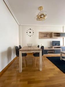 FuenmayorにあるApartamento Canelaのテーブルと椅子と時計のあるダイニングルーム