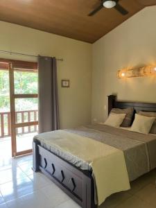 een slaapkamer met een bed en een plafondventilator bij Siquirres Mountain Lodge in Siquirres