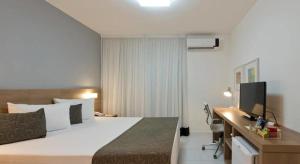 una camera da letto con un letto e una scrivania con una televisione di Best-Inn By Rio Stay suítes a Rio de Janeiro Altre 23 foto