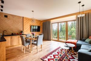 a kitchen and living room with a table and chairs at Apartamenty Blisko TATR Zakopane in Zakopane