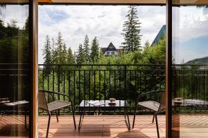 a patio with a table and chairs on a balcony at Apartamenty Blisko TATR Zakopane in Zakopane