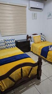 two beds sitting next to each other in a room at Casita Playera Aguadeña 