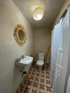 Un baño con lavabo, inodoro y espejo. en Riad Mama Toutou, en Marrakech