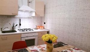 una cucina con tavolo e vaso di fiori gialli di Napulè a Napoli