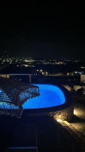 una piscina azul por la noche con vistas en Diamond Of Mykonos, en Ano Mera