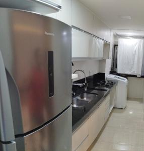 eine Küche mit einem Kühlschrank aus Edelstahl und einer Spüle in der Unterkunft Top Place in Vitória