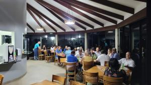 een groep mensen die aan tafels in een restaurant zitten bij Pousada Chez bubônia in Novo Acordo