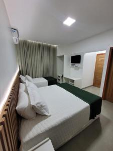 een hotelkamer met twee bedden en een televisie bij Pousada Chez bubônia in Novo Acordo +3 foto's