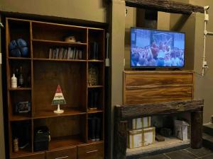 a living room with a tv and a book shelf at Pura Vida in Yapeyú