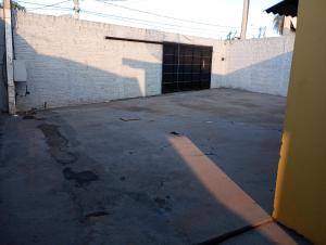 um parque de estacionamento vazio ao lado de um edifício de tijolos em Pousada do Julio em Barretos
