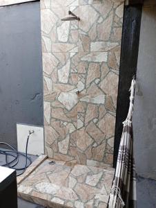 y baño con ducha y pared de piedra. en Pousada do Julio en Barretos