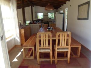 a wooden dining room table with chairs and a kitchen at Casa Tunquén in Tunquen +19 photos