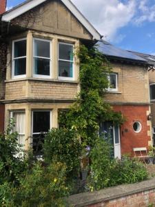 una casa di mattoni con edera che cresce sopra di Balcarres, Rodborough Avenue a Stroud