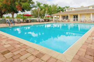 a swimming pool with blue water in front of a house at Palm Key Oasis - Close to Attractions in Davenport