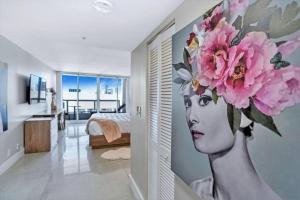 ein Zimmer mit einem Bild einer Frau mit Blumen an der Wand in der Unterkunft Champagne & Ice! Water Views, 2 Private Balconies! in Miami