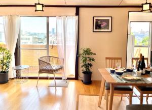 a living room with a table and chairs and a balcony at 东京新宿区早稻田地铁步行5分钟Viewing House in Tokyo