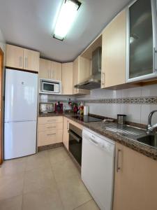 ミハス・コスタにあるApartamento con vistasのキッチン(白い家電製品、白い冷蔵庫付)