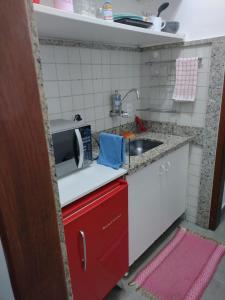 a small kitchen with a microwave and a sink at Apartamento aconchegante no Sudoeste in Brasília