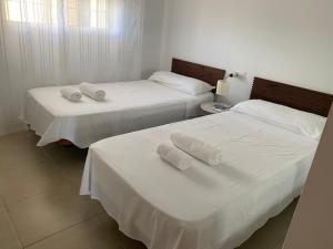 ミハス・コスタにあるApartamento con vistasのベッド2台(白いシーツ、タオル付)
