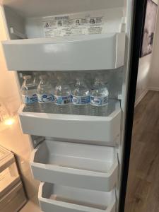 a refrigerator filled with bottles of water at 10 Min to Sea World & Lackland, Pets OK, Sleeps 12 in San Antonio