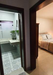 a room with a bedroom with a bed and a mirror at Casa Romão 2 Pertinho de Vinícola e Centro in Espirito Santo Do Pinhal