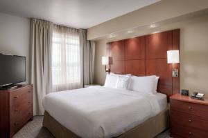 a hotel room with a bed and a flat screen tv at Residence Inn by Marriott Idaho Falls in Idaho Falls