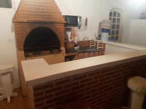un forno in mattoni in una cucina con bancone di Giardino Mediterraneo a São Pedro