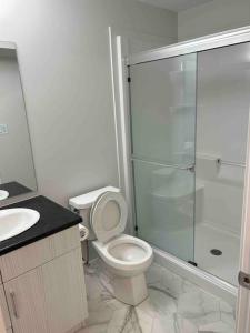 a bathroom with a toilet and a glass shower at Homestay in Winnipeg