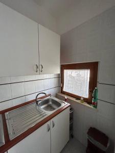 a small kitchen with a sink and a window at PM 15 Via Liguria Guest House in Alghero