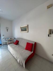 a couch with two red pillows in a room at PM 15 Via Liguria Guest House in Alghero