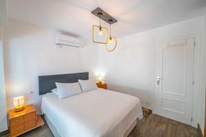 a bedroom with a large white bed and a lamp at Costa Blanca Holiday Rental La Cenia I in El Campello +20 photos