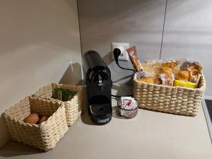 a blender and baskets of bread and eggs on a counter at Appartamento di 45mq a Balerna in Balerna