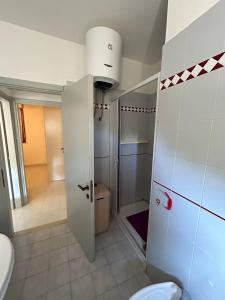 a bathroom with a toilet and a door to a room at PM 15 Via Liguria Guest House in Alghero