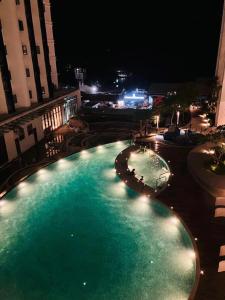 ein großer Swimmingpool in der Nacht mit Lichtern in der Unterkunft Ems Executive Suites Home in Kota Kinabalu