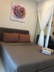 Bett in einem Zimmer mit Fenster in der Unterkunft Ems Executive Suites Home in Kota Kinabalu