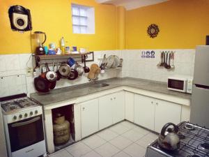 a kitchen with yellow walls and white cabinets and a sink at Casa Copada in Montevideo